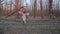 Cute young woman in image of witch and old Slavic costume runs through forest