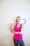 Cute young woman with a racket leaning against a wall in a squash