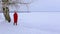 Cute young woman stands near birch on snow-covered bank of river and looks at pictorial landscape