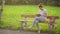 Cute young woman with tablet in the park, beautiful woman using a tablet on a bench in the garden, young female student