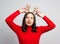 Cute young woman trying on christmas deer antlers on white background