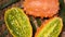 Cuted african horned melon on rotating background. Top view. Exotic Kiwano melon fruits, tropical palm branch. Vegan and