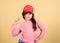 Cutie in cap. Girl cute child wear cap or snapback hat beige background. Little girl wearing bright baseball cap. Modern