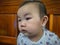 Cutie and handsome asian boy baby or infant make a face like interested