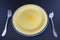 Cutlery language, dining etiquette - Start course. Yellow ceramic round plate with spoon