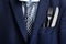 Cutlery and pen in breast pocket of men`s jacket as background, closeup. Business lunch concept