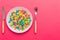 cutlery on table and sweet plate of candy. Health and obesity concept, top view on colored background