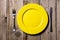 Cutlery and yellow plate on wooden