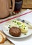 Cutlet, mashed potatoes with butter and parsley and tea on a wooden table.