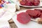 Cutting beetroot on white chopping board over on old wooden table.