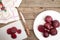 Cutting beetroot on white chopping board over on old wooden table.