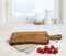 Cutting board above linen tablecloth on wooden table. Cooking concept