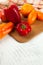 Cutting board with assort of different tomatoes and bell pepper on white wooden background