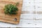 Cutting board with a bunch of fresh dill against rustic wooden background