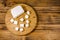 Cutting board with chopped feta cheese on a wooden table. Top view