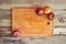 Cutting board and colorful onions on aged wooden background.