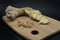 Cutting board of different types of Ginger. Raw ginger, sliced ginger and dehydrated ginger cubes on black background