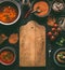 Cutting board food background of healthy vegan lentil dishes on dark kitchen table background with ingredients, top view.