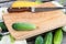 Cutting board, knife, fresh vegetables on wooden table. Top vie