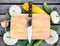 Cutting board, knife, fresh vegetables on wooden table. Top vie