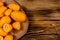 Cutting board with kumquat fruits on wooden table. Top view