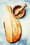 Cutting board and mortar with pestle made from olive wood, food