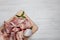 Cutting board with raw chopped meaty bones and basil on white wooden table, top view. Space for text