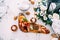 Cutting board with sliced prosciutto, sausage and cheese on the table with bowls of salad and a bouquet of flowers.