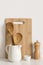 Cutting board, spoons and spice mill on table wall background