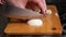 Cutting boiled egg. Female hands cut boiled egg a large knife on a wooden cutting board