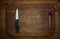 Cutting breadboard and knife overwooden background