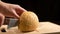 Cutting the bun with sesame seeds with a kitchen knife on wooden