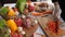 Cutting carrots on a wooden board, against the backdrop of chicken, beef, cape, vegetables. Still life. Side view