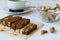 Cutting chocolate and milk sherbet with nuts and peanuts on the white table.