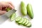 Cutting cucumbers into small slices on white background isolated