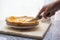 Cutting delicious homemade lemon apricot pie with a sharp knife on wooden board