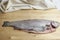 Cutting gutted red fish trout sweetfish on wood background