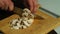 Cutting mushrooms on a wooden Board. Man cuts mushrooms