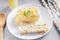 Cutting a piece of chilled savory chicken pie, a typical Brazilian dish. In white plate, gray wooden background. Next to a wooden