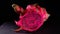 Cutting Pitahaya, dragonfruit on a black background, close-up rotation