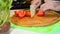 cutting red bell pepper with cleaver. Close up on the chefs hands. Healthy food preparation