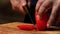 Cutting red tomato on wooden board. Stock footage. Chef cut tomato on a wooden Board
