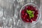 Cutting roots of cooked peeled beet salad in glass plate on the black background