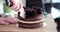 Cutting slice of birthday cake and closeup of knife cutting chocolate cake