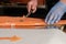 Cutting smoked salmon close detail