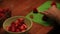 Cutting strawberries near bowl