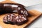 Cutting tasty blood sausage on white table, closeup