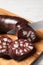 Cutting tasty blood sausage on wooden board, closeup