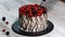 Cutting trendy rustic vertical roll high cake with berry.