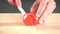 Cutting whole red tomato with ceramic knife